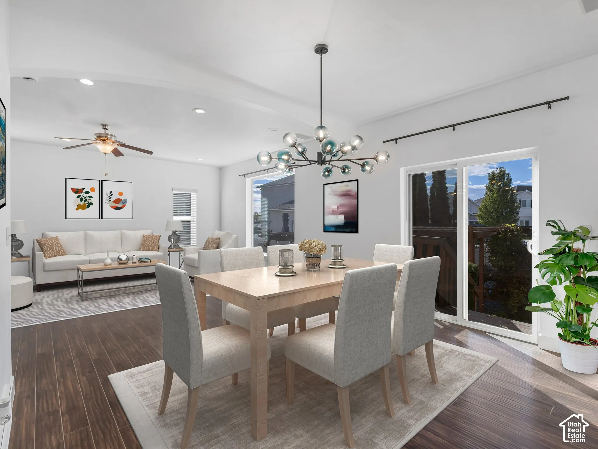 Open-concept floor plan featuring arched architectural details, wood-finish flooring, a multi-globe chandelier, recessed lighting, and glass sliding doors