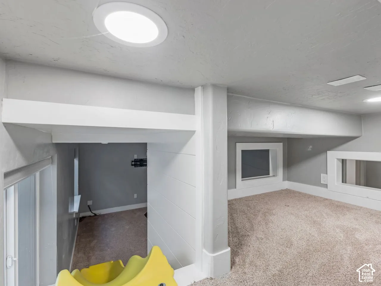 Interior space featuring wall-to-wall carpeting, recessed ceiling lighting, and horizontal white paneling