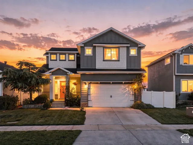 Two-story residence featuring composite siding, a front-facing attached two-car garage, multiple gabled rooflines, and decorative shingle accents