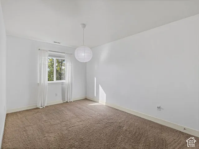 Neutral-toned wall-to-wall carpeting, crisp white wall finish, and a spherical pendant lighting fixture
