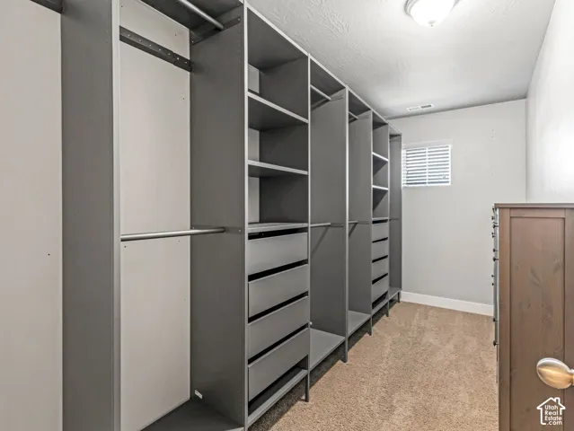 Custom floor-to-ceiling closet organization system featuring adjustable shelving, multiple pull-out drawers, and hanging rods