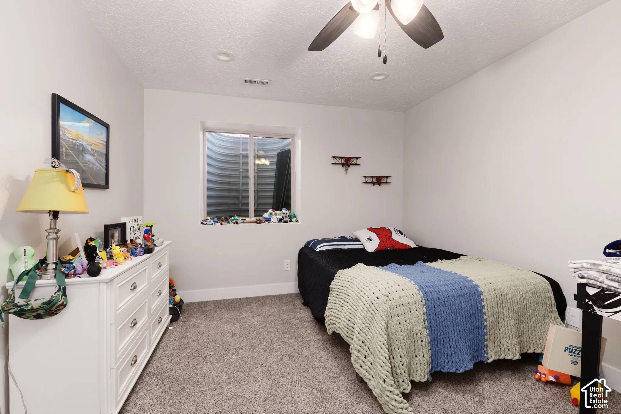 Room featuring neutral carpeting, a ceiling fan with integrated lighting, recessed overhead lighting, and an egress window with a corrugated metal window well