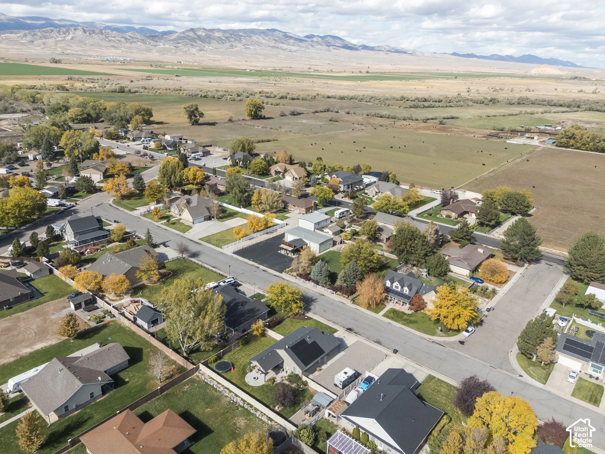 Aerial perspective featuring residential lots with paved street access and mountain range backdrop