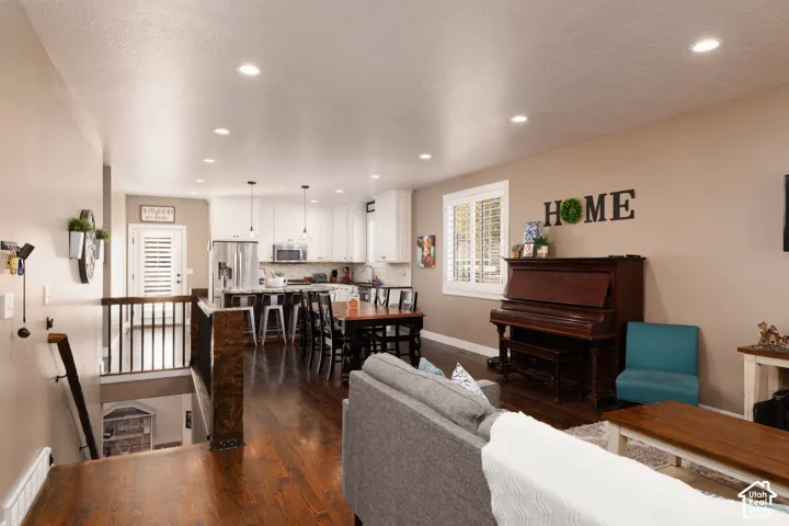 Open-concept interior featuring wood-finish flooring, recessed lighting, and white kitchen cabinetry