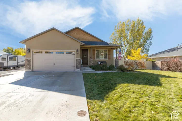Single-story exterior featuring stucco and wood-shake siding, stone masonry accents, a two-car garage, and a covered front porch