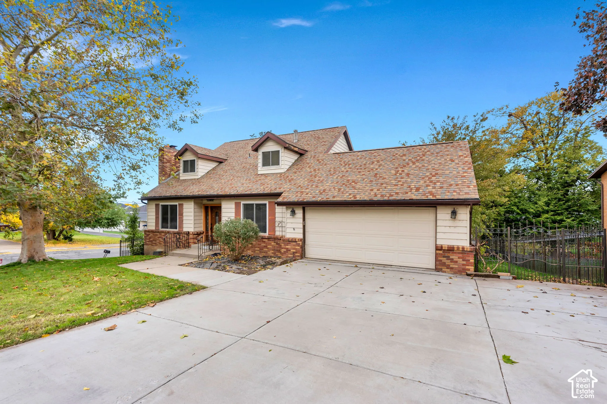 Two-story residence featuring a combination of brick and horizontal siding, a multi-gable shingle roofline, an attached two-car garage, and concrete driveway