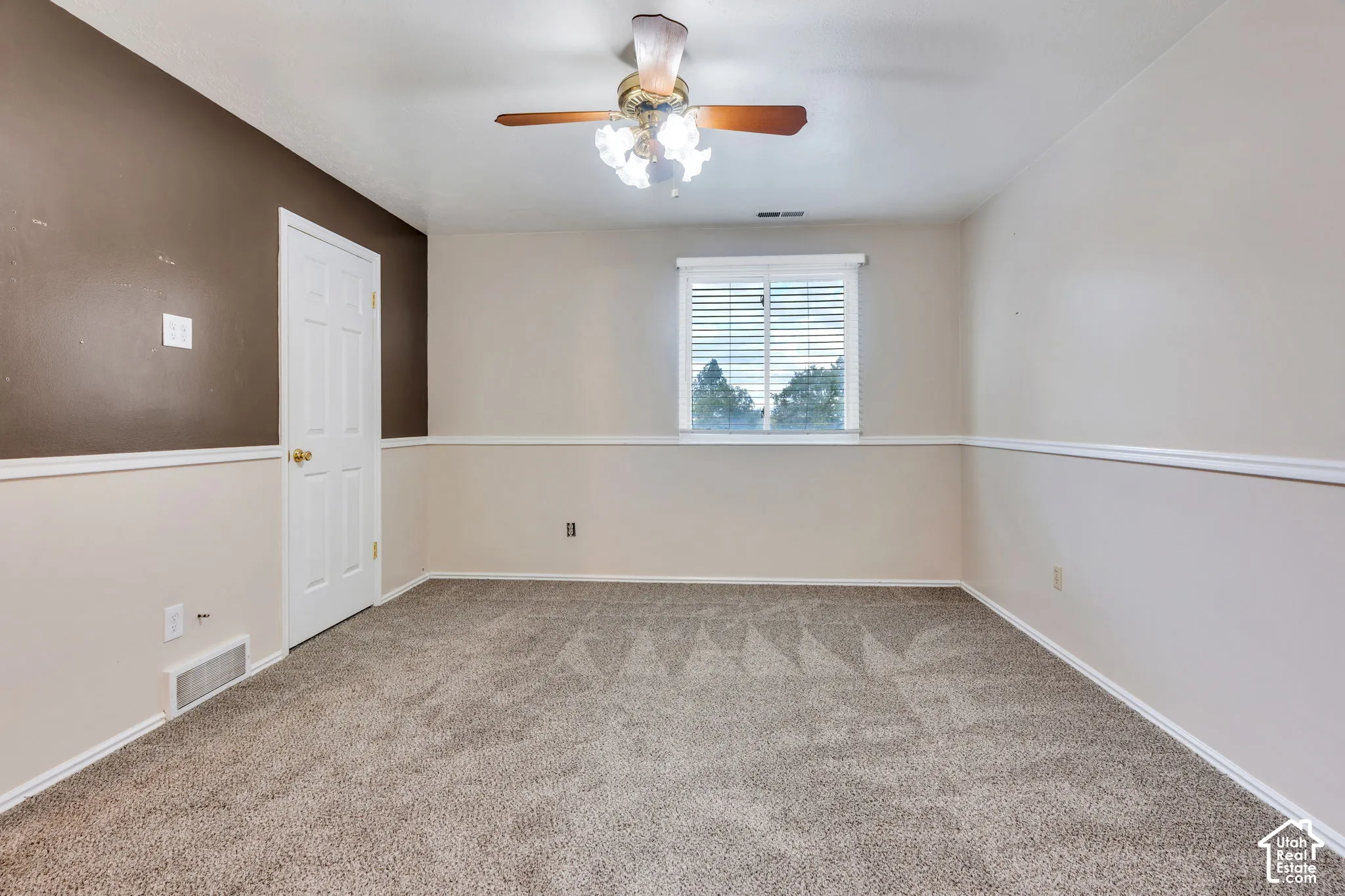 Interior room featuring carpeting, chair rail molding, a multi-light ceiling fan, and a single-pane window with installed blinds