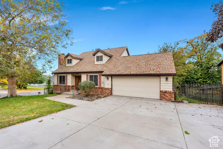 Two-story residence featuring a combination of brick and horizontal siding, a multi-gable shingle roofline, an attached two-car garage, and concrete driveway