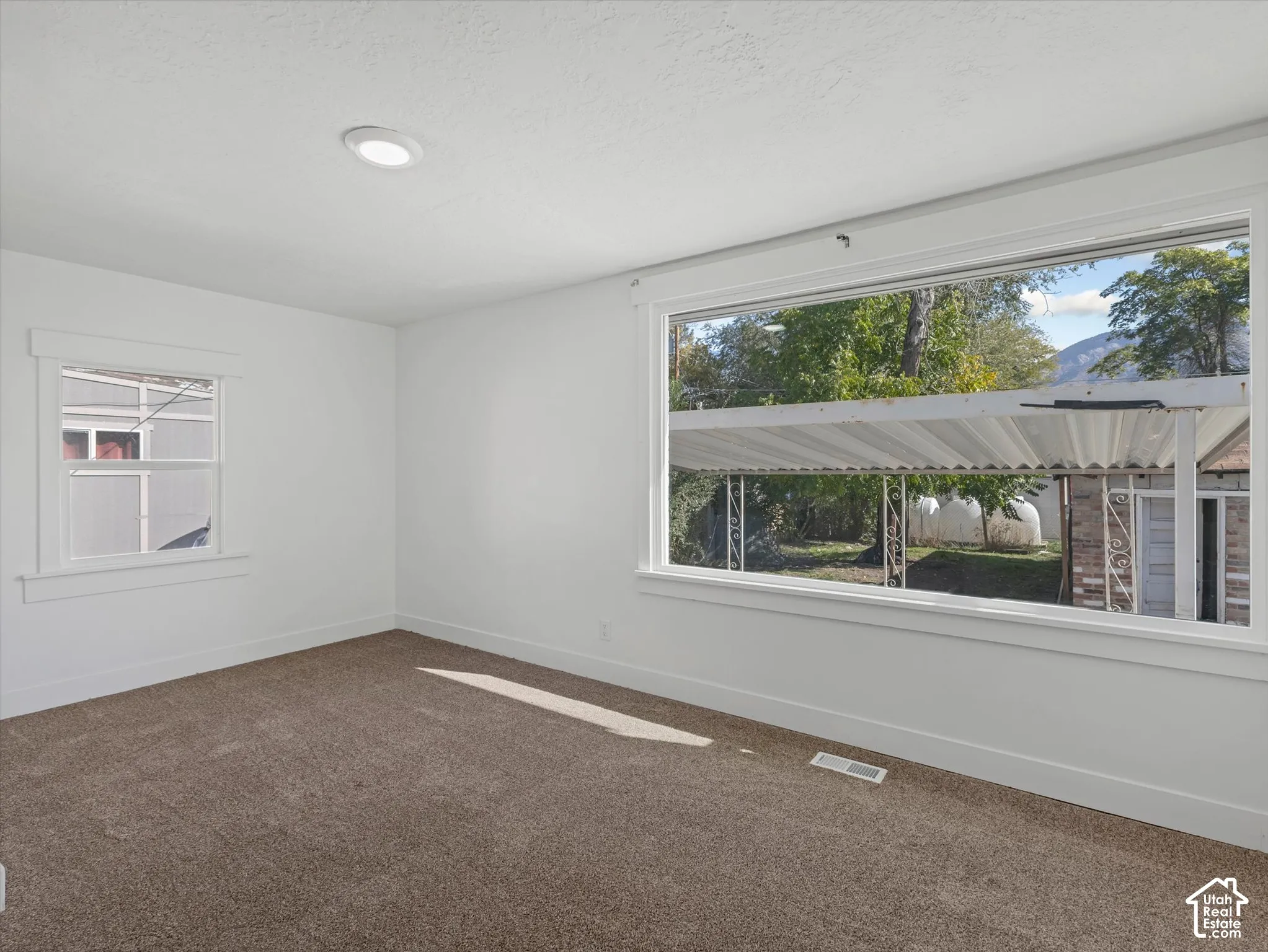 Interior space featuring neutral wall tones, wall-to-wall carpeting, recessed ceiling lighting, and a large picture window