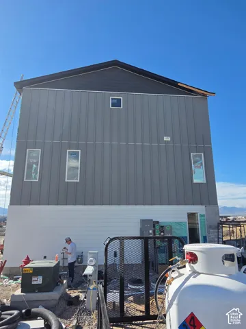 Exterior elevation featuring multi-tone vertical siding, horizontal lap siding, and energy-efficient windows