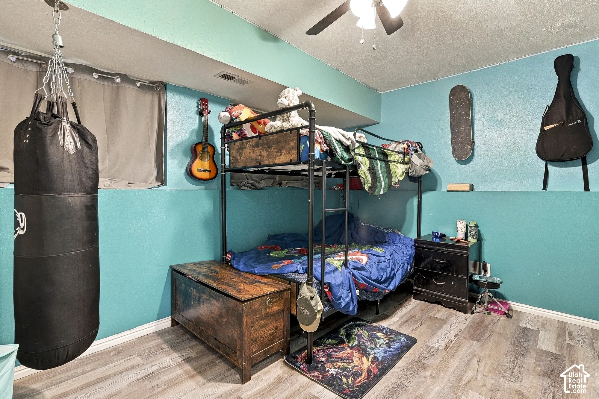 Room featuring wood-finish flooring, a ceiling fan, and painted walls