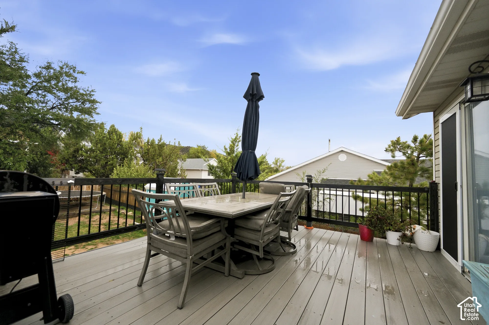 Elevated composite deck featuring black metal railings and exterior wall-mounted lighting