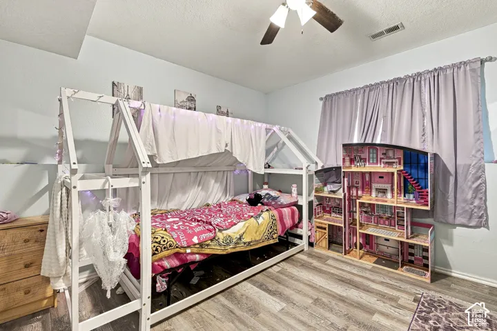 Wood-finish flooring and a central ceiling fan with integrated lighting
