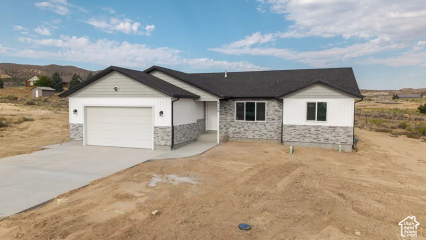 Single-story exterior featuring stone veneer siding, vertical board-and-batten accents, horizontal lap siding, an attached two-car garage, and asphalt shingle roofing