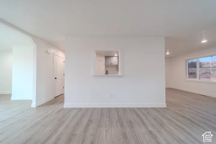 Interior space featuring light wood-finish flooring, recessed lighting, and a central architectural cutout with a ledge