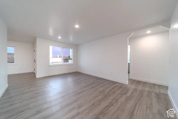 Neutral-toned wood-finish flooring, recessed lighting, and expansive windows