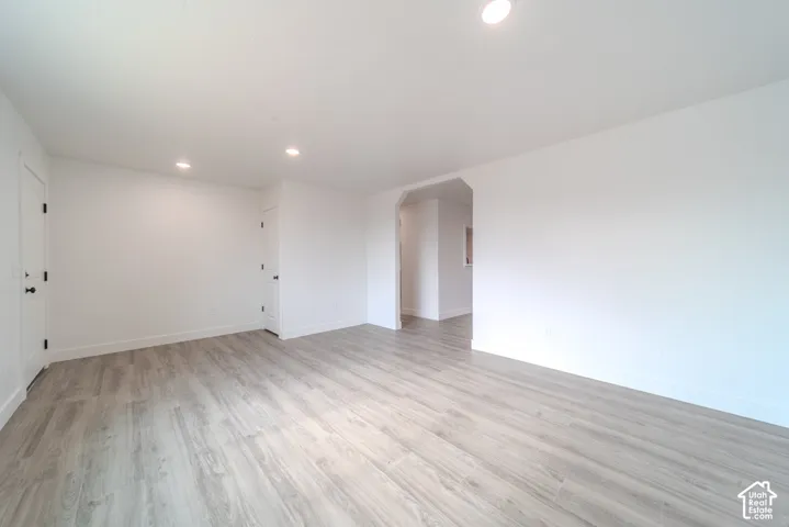 Interior room featuring wood-finish flooring, recessed lighting, and a wide arched opening