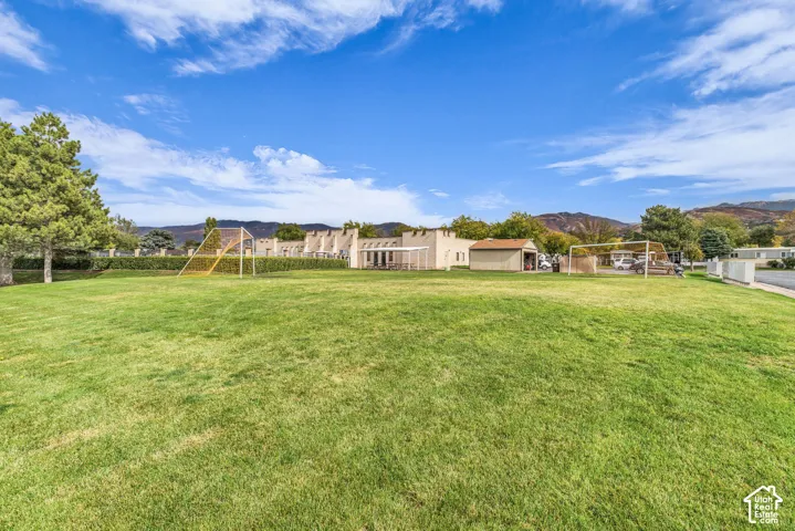 Expansive lawn featuring mature trees and mountain scenery