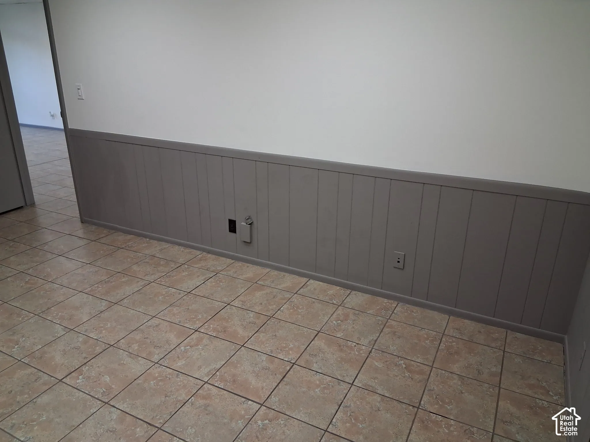 Interior space featuring ceramic tile flooring and grey vertical wainscoting with a matching chair rail