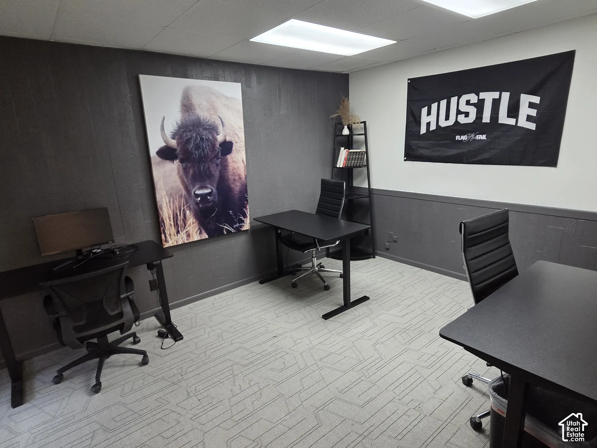 Room featuring dark-toned paneled walls, patterned carpeting, and recessed ceiling lighting