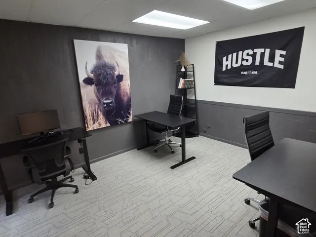 Room featuring dark-toned paneled walls, patterned carpeting, and recessed ceiling lighting