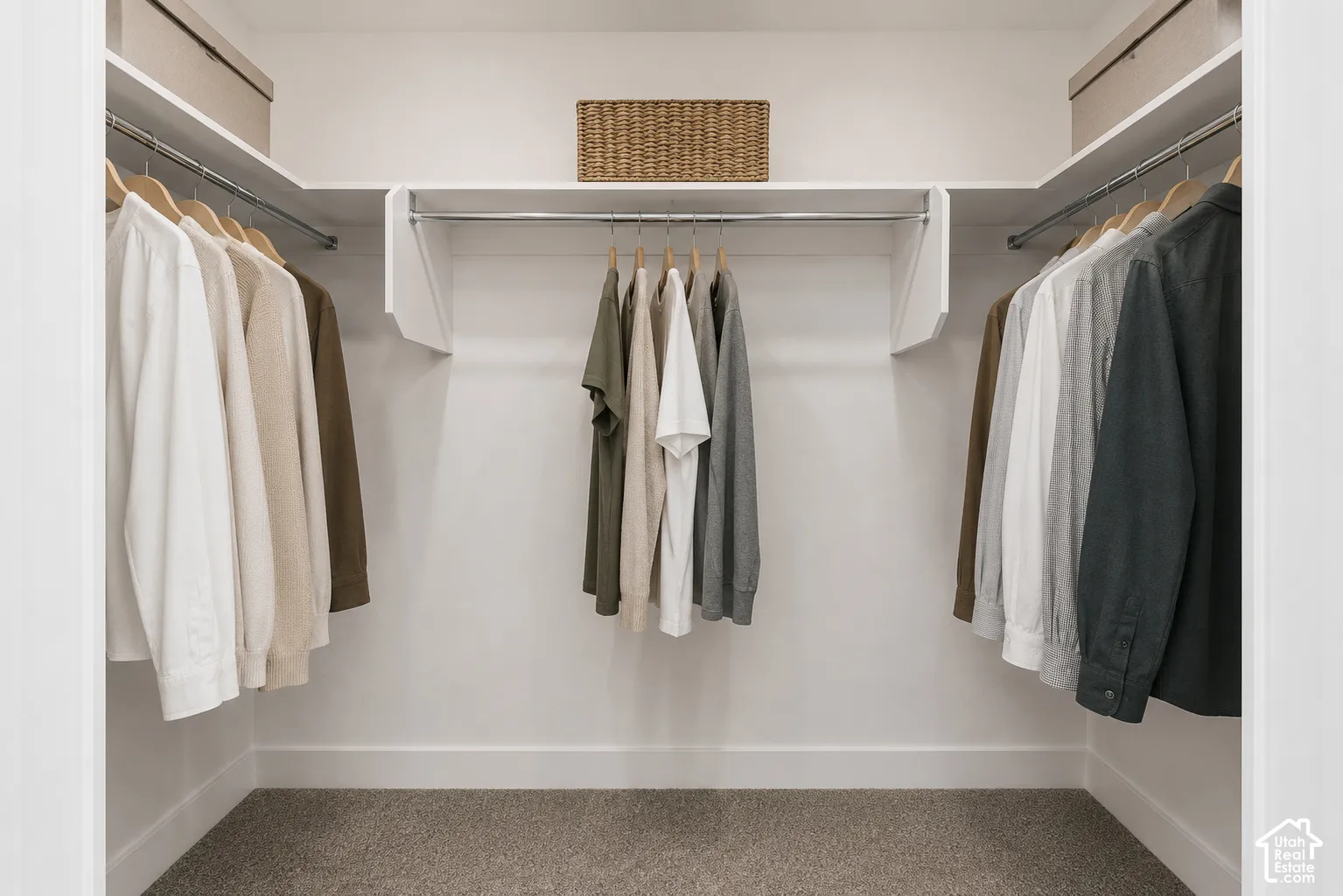 Walk-in closet featuring tiered white shelving and integrated metal garment rods