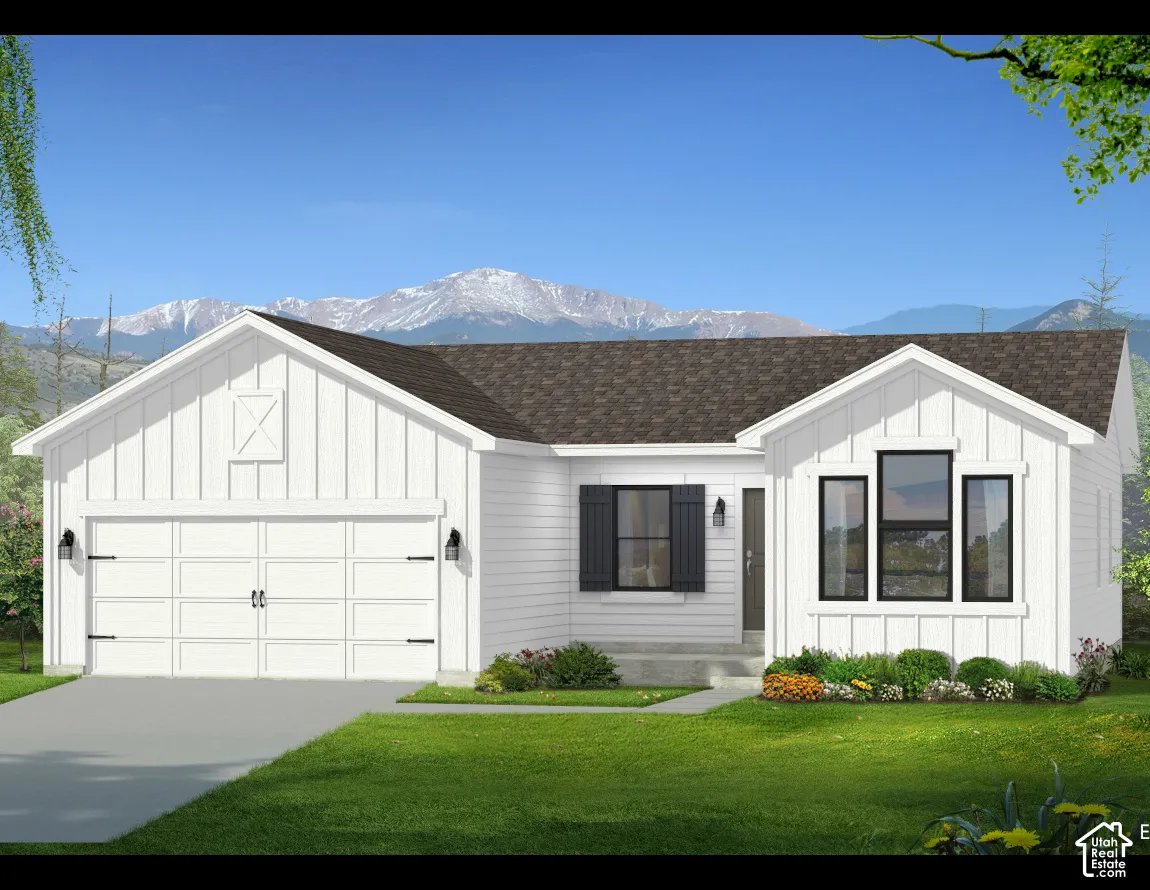 Exterior featuring white vertical siding, a multi-gabled roofline, dark-toned shutters, a double-car garage, and a backdrop of snow-capped mountains