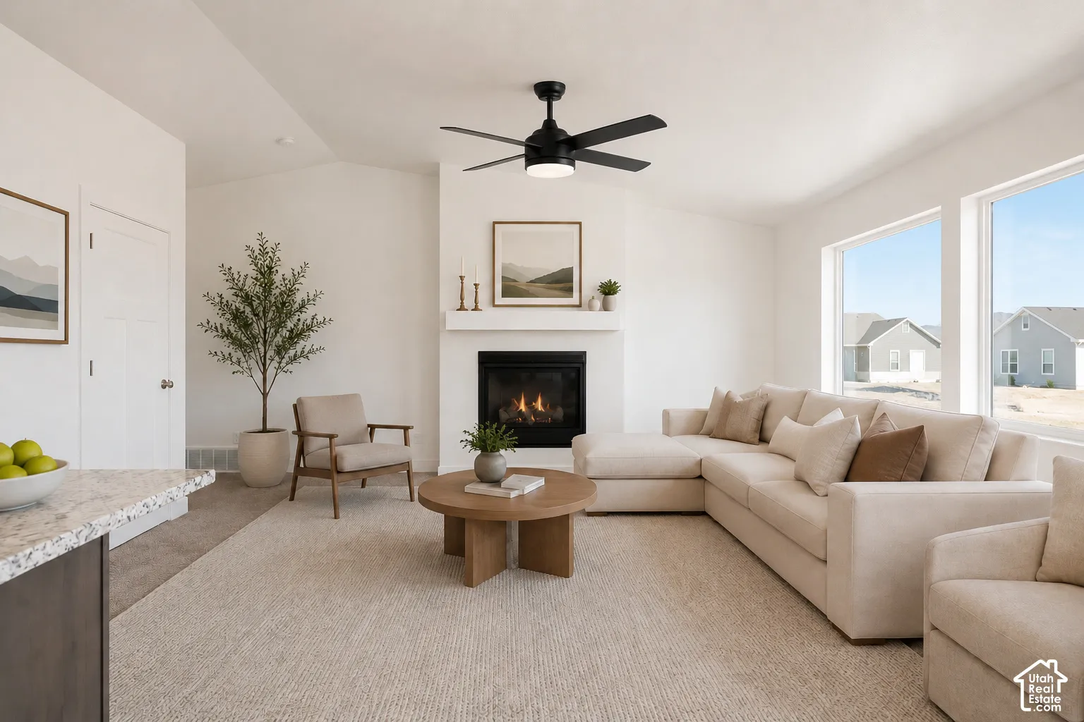 Fireplace with a white mantel, large picture windows, matte black ceiling fan with integrated lighting, and neutral wall tones
