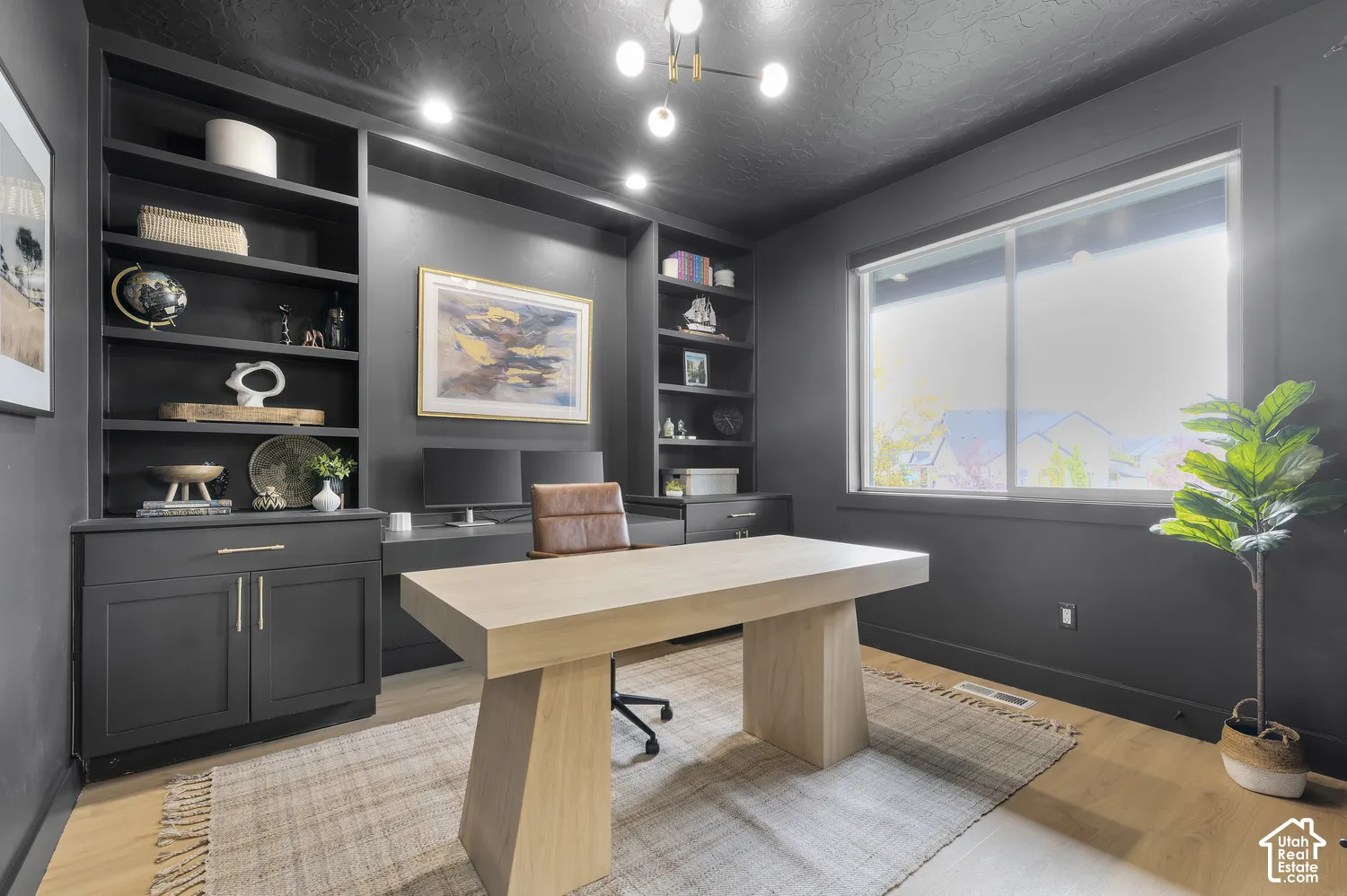 Built-in floor-to-ceiling cabinetry with open shelving, wood-finish flooring, sliding window with casing, and modern multi-bulb chandelier