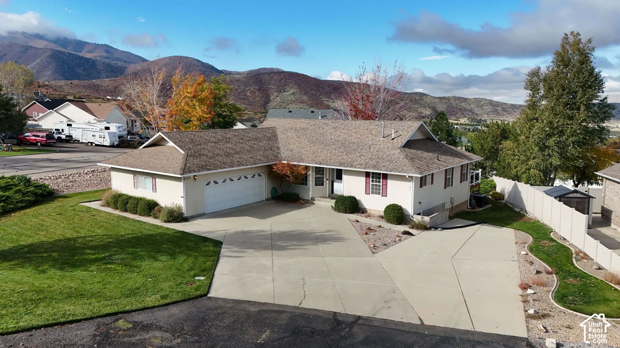 Ranch-style residence featuring a multi-car concrete driveway, attached two-car garage, and mountain backdrop
