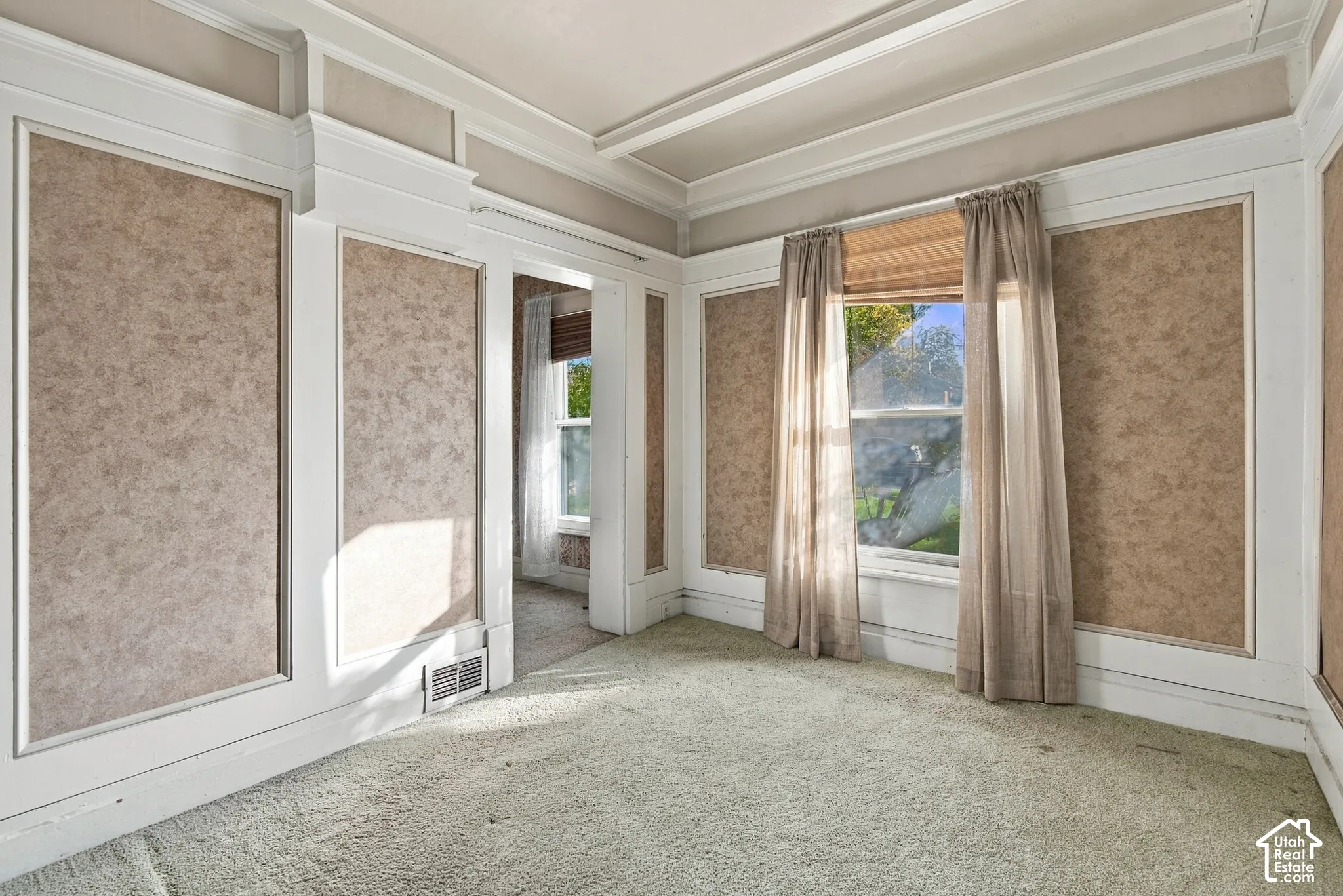 Interior room featuring decorative wall molding, crown molding, and high-profile wainscoting