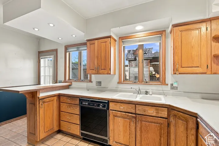 Kitchen featuring oak cabinetry, solid-surface countertops, a double-basin sink, and recessed lighting