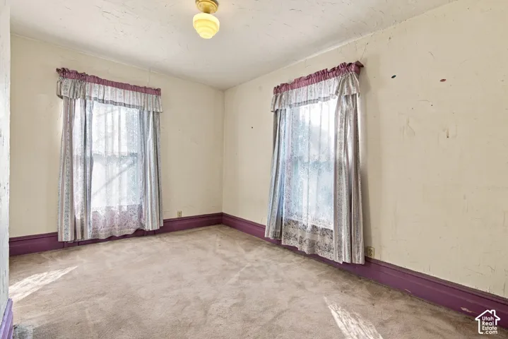 Room featuring dual windows, wall-to-wall carpeting, and a central ceiling-mounted globe light fixture