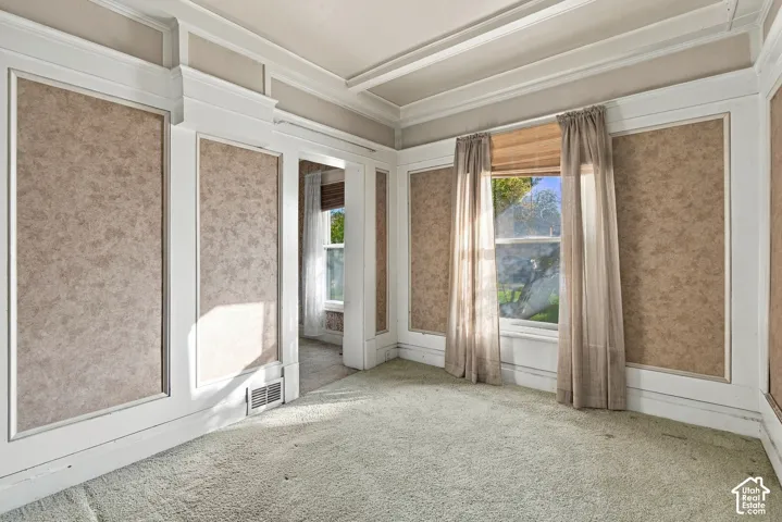 Interior room featuring decorative wall molding, crown molding, and high-profile wainscoting