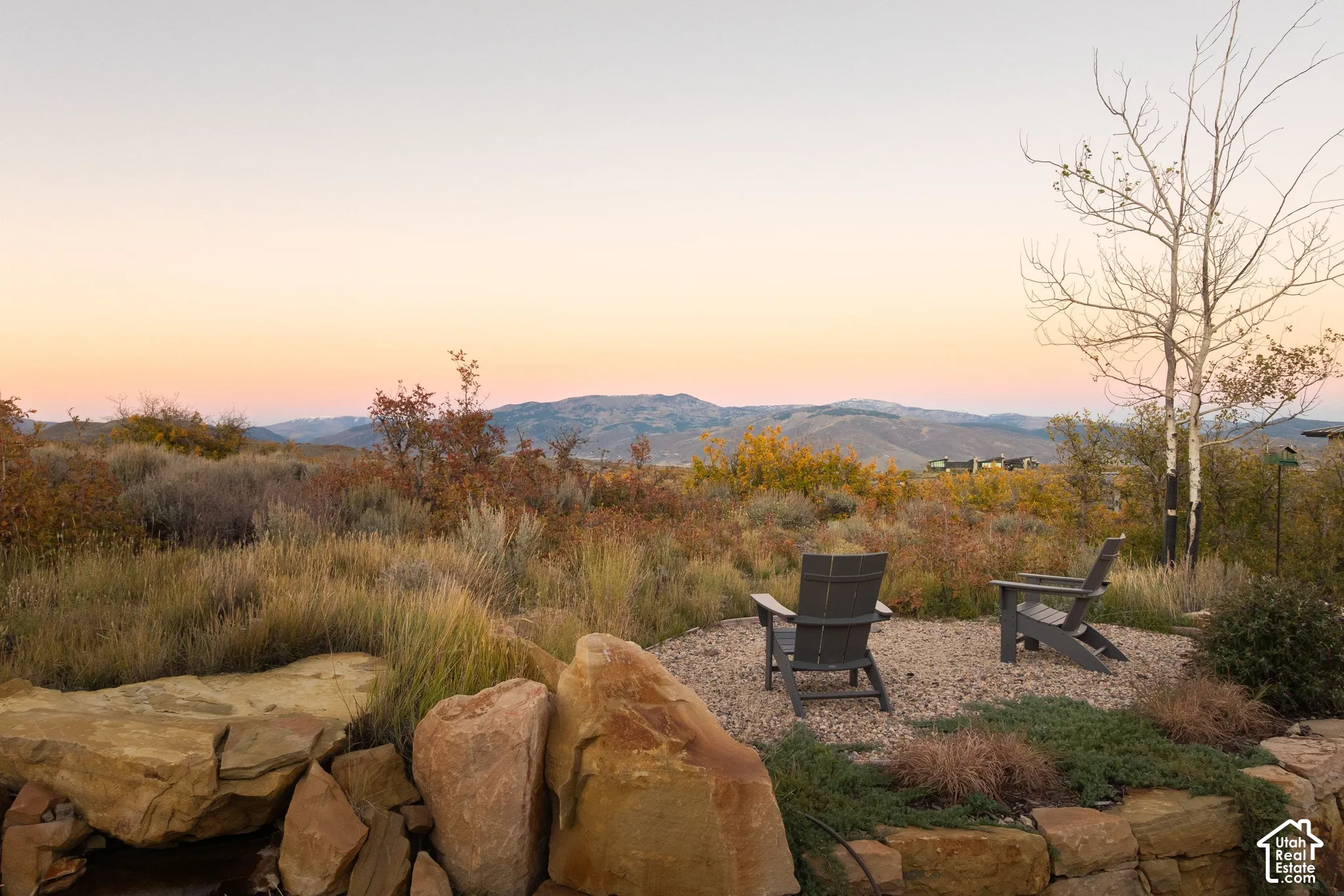 Natural stone retaining wall, gravel hardscaping, and mountain backdrop