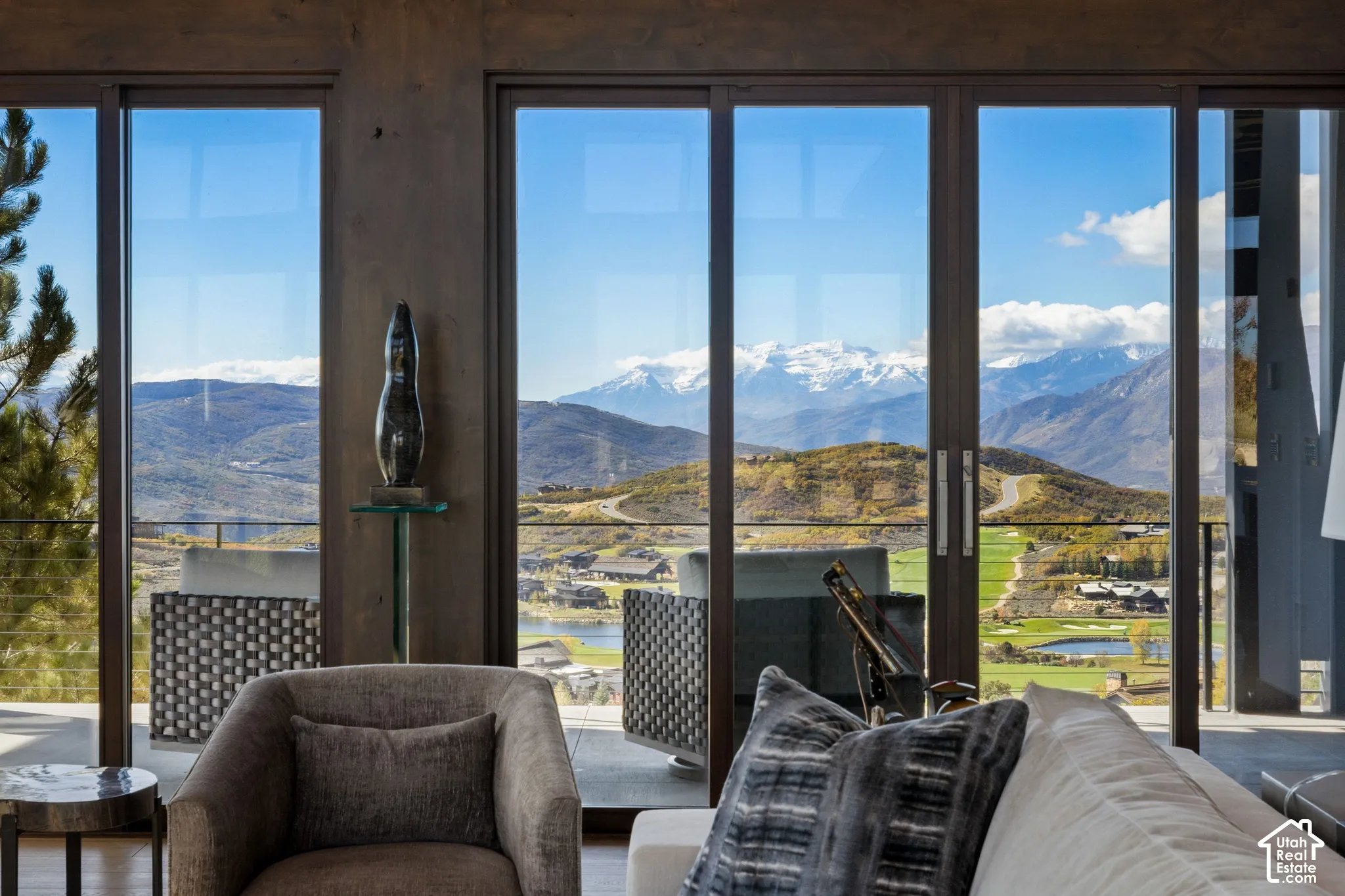 Floor-to-ceiling multi-panel sliding glass doors with dark-toned framing and expansive mountain scenery