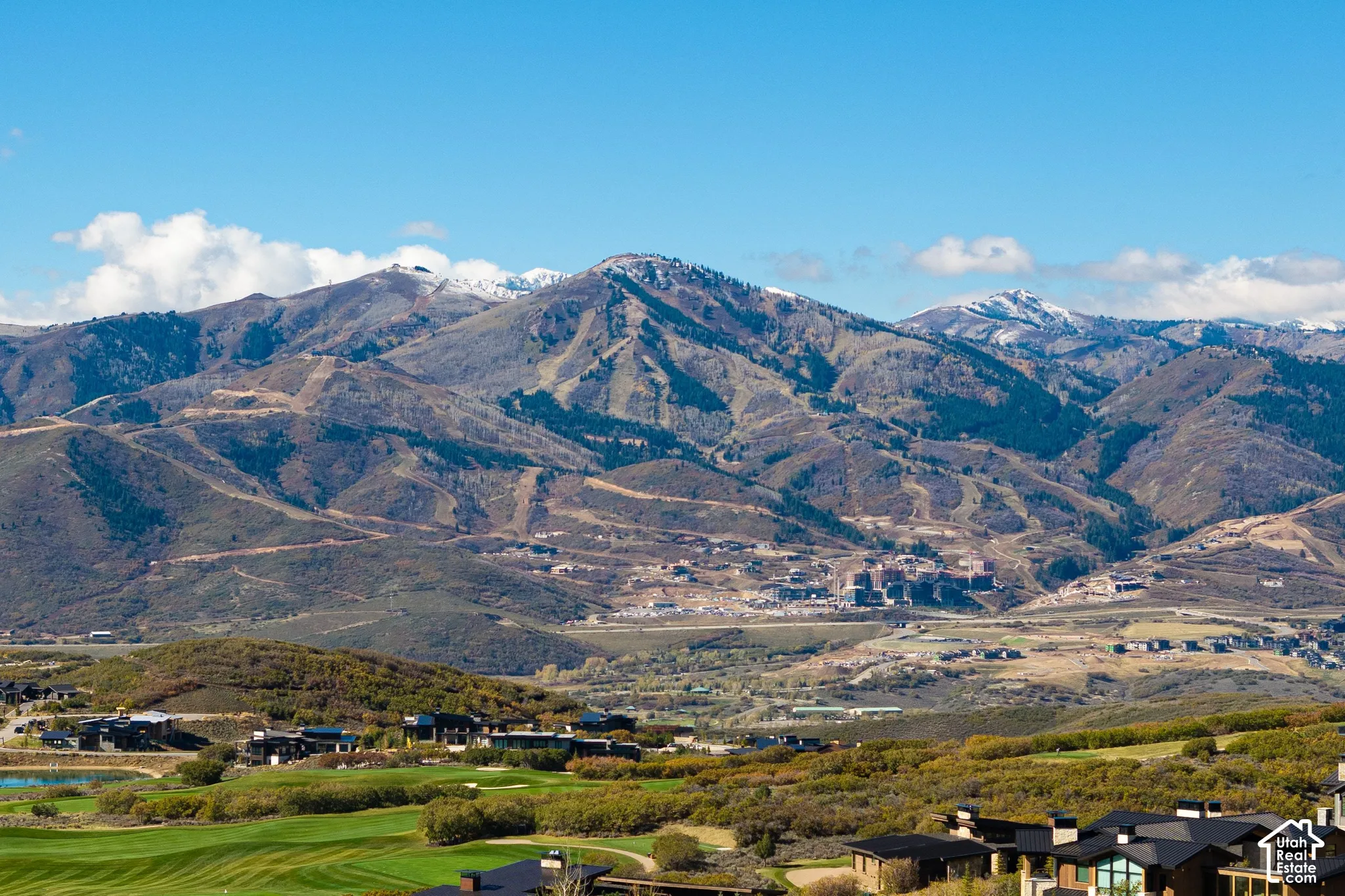 Expansive landscape featuring mountain ranges, rugged terrain, and proximity to open green space