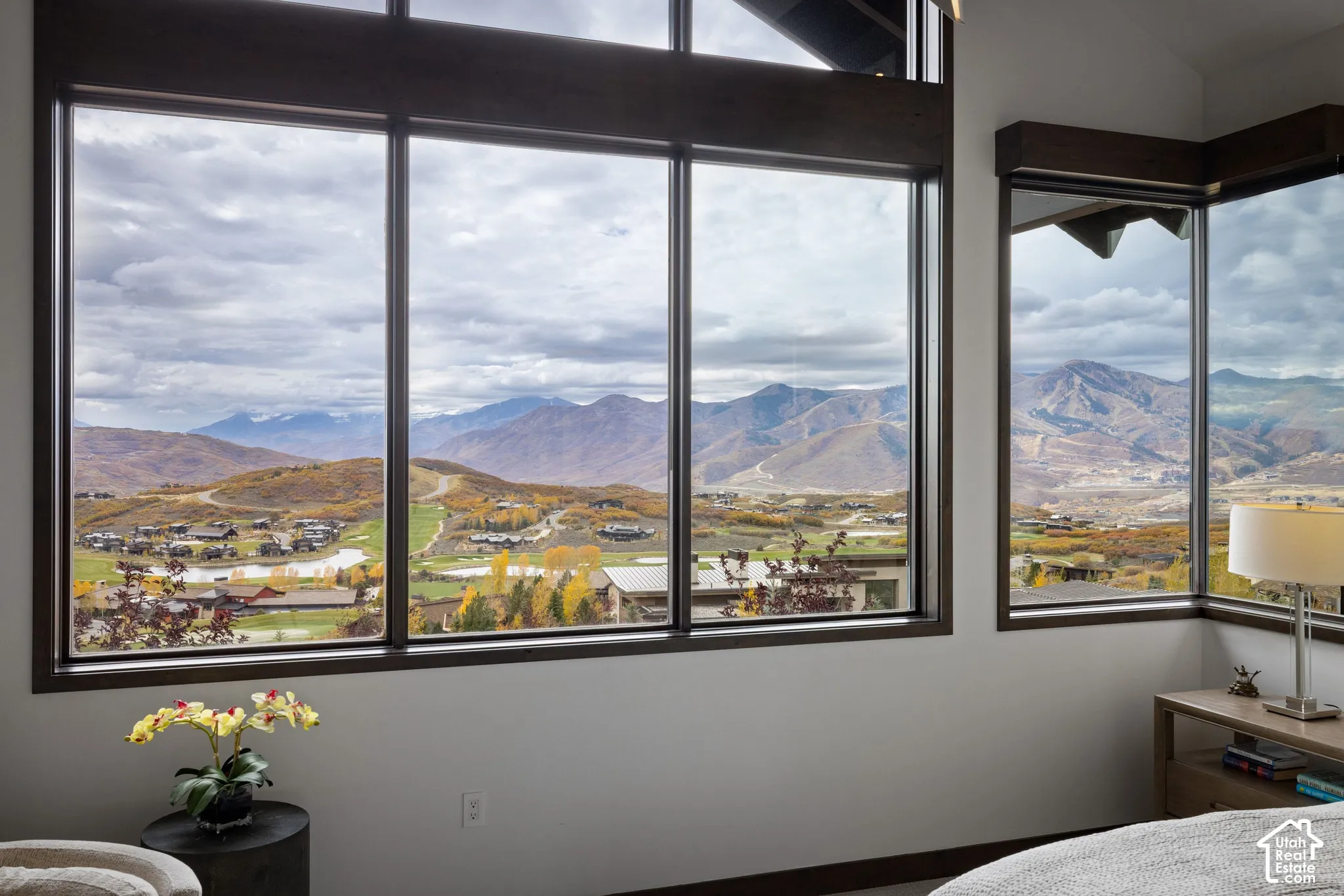 Floor-to-ceiling windows featuring dark-toned framing, vaulted ceilings, and expansive mountain scenery