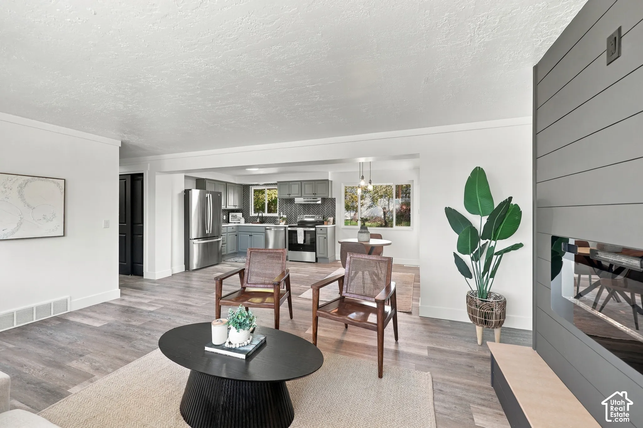 Living area featuring wood-finish flooring, a horizontal paneled accent wall, and a built-in fireplace