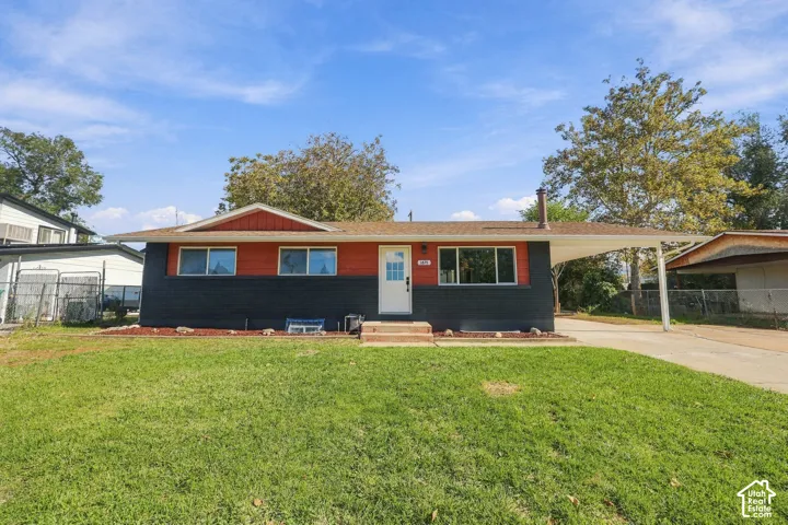 Ranch-style exterior featuring a brick facade, dual-tone paint finish, concrete driveway, and attached carport