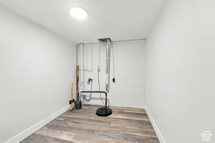 Wood-finish flooring, neutral wall paint, and overhead flush-mount lighting