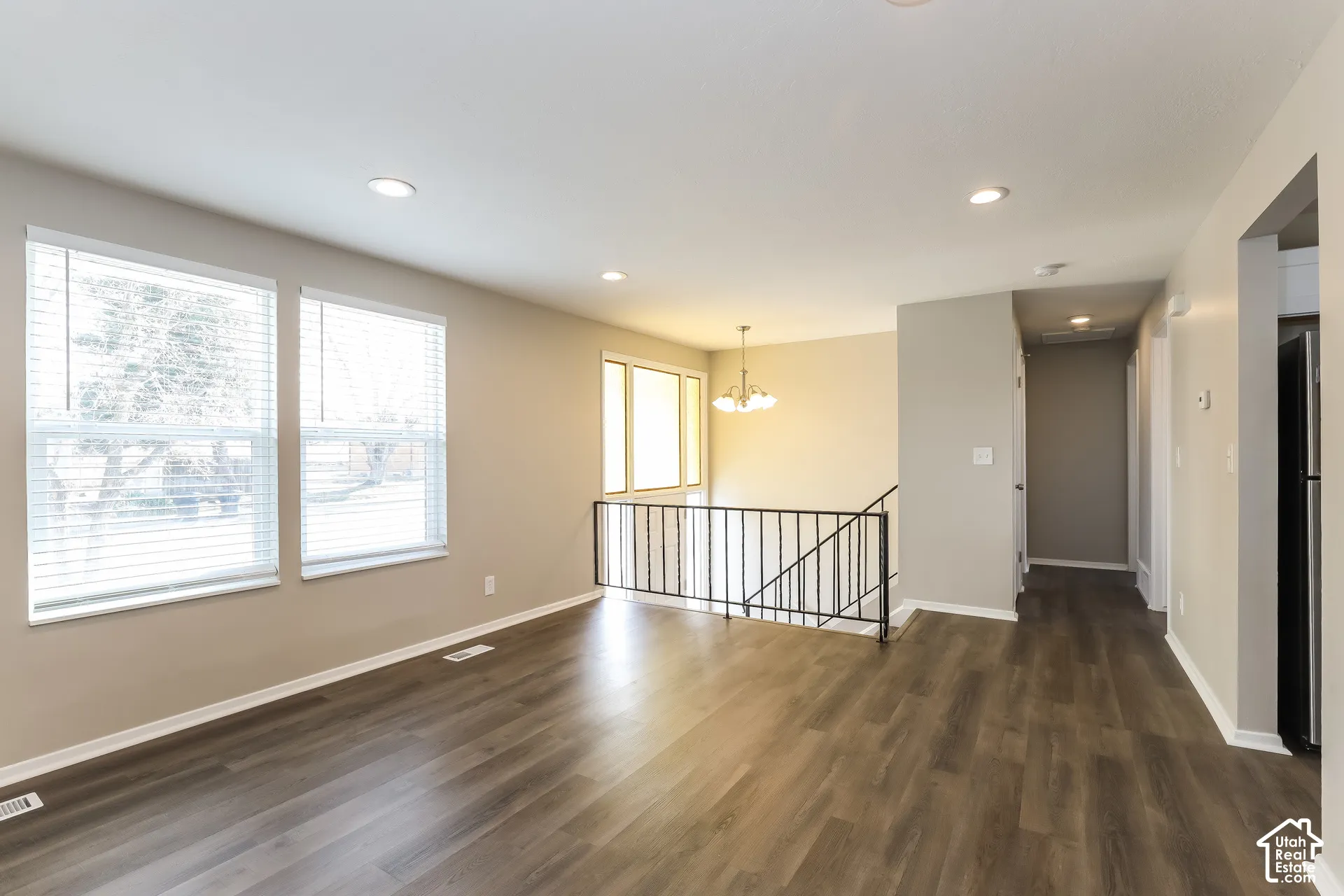 Wood-finish flooring, recessed lighting, multi-pane windows, and metal stair railing