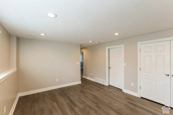 Interior space featuring wood-finish flooring, recessed lighting, and white six-panel doors