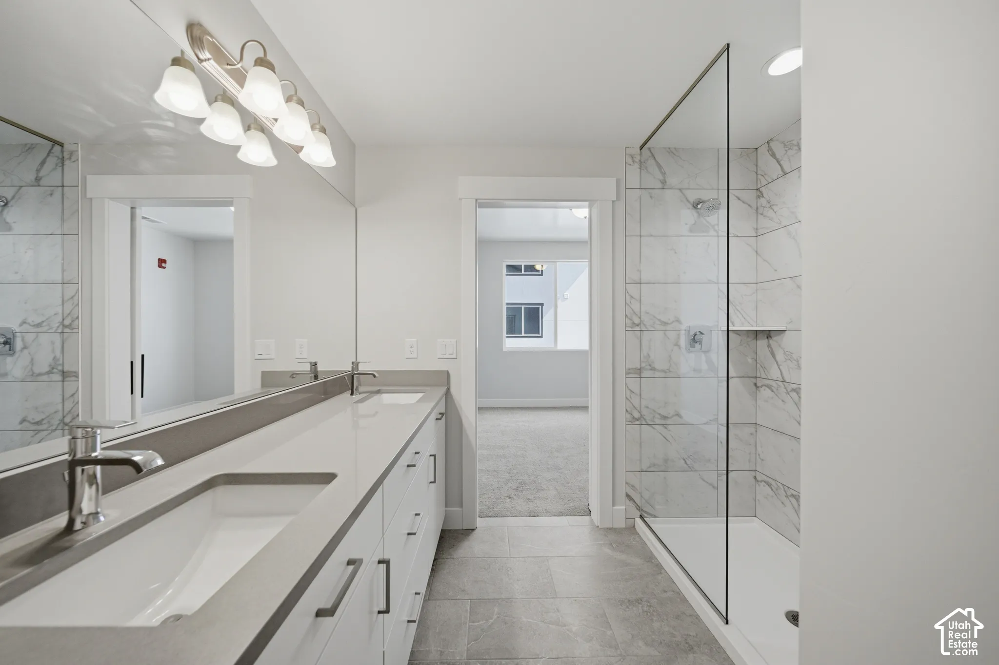 Dual vanity with white cabinetry, integrated sinks, and polished chrome faucets