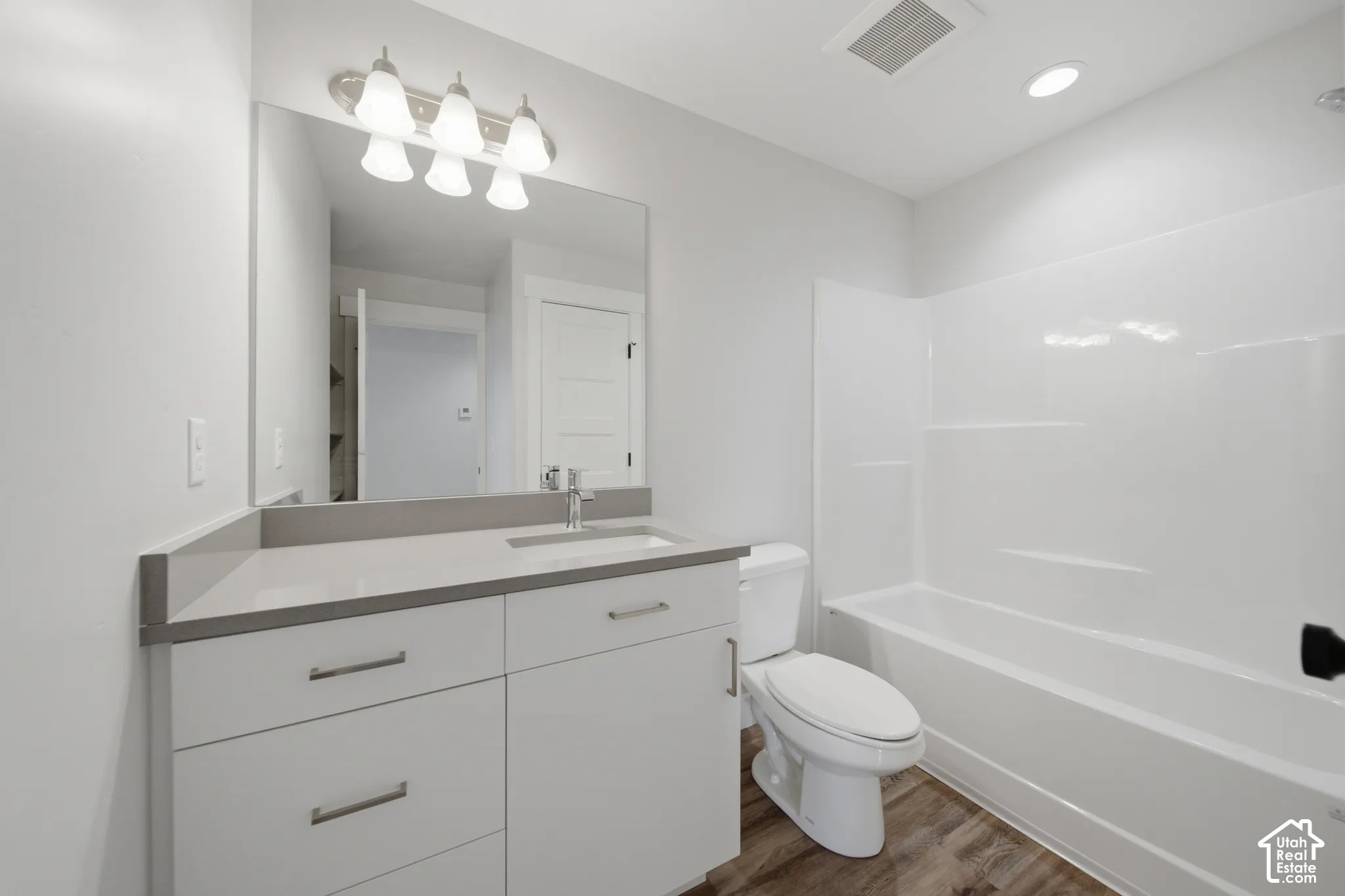 Bathroom featuring a contemporary vanity with a stone countertop, an integrated sink, and brushed nickel hardware