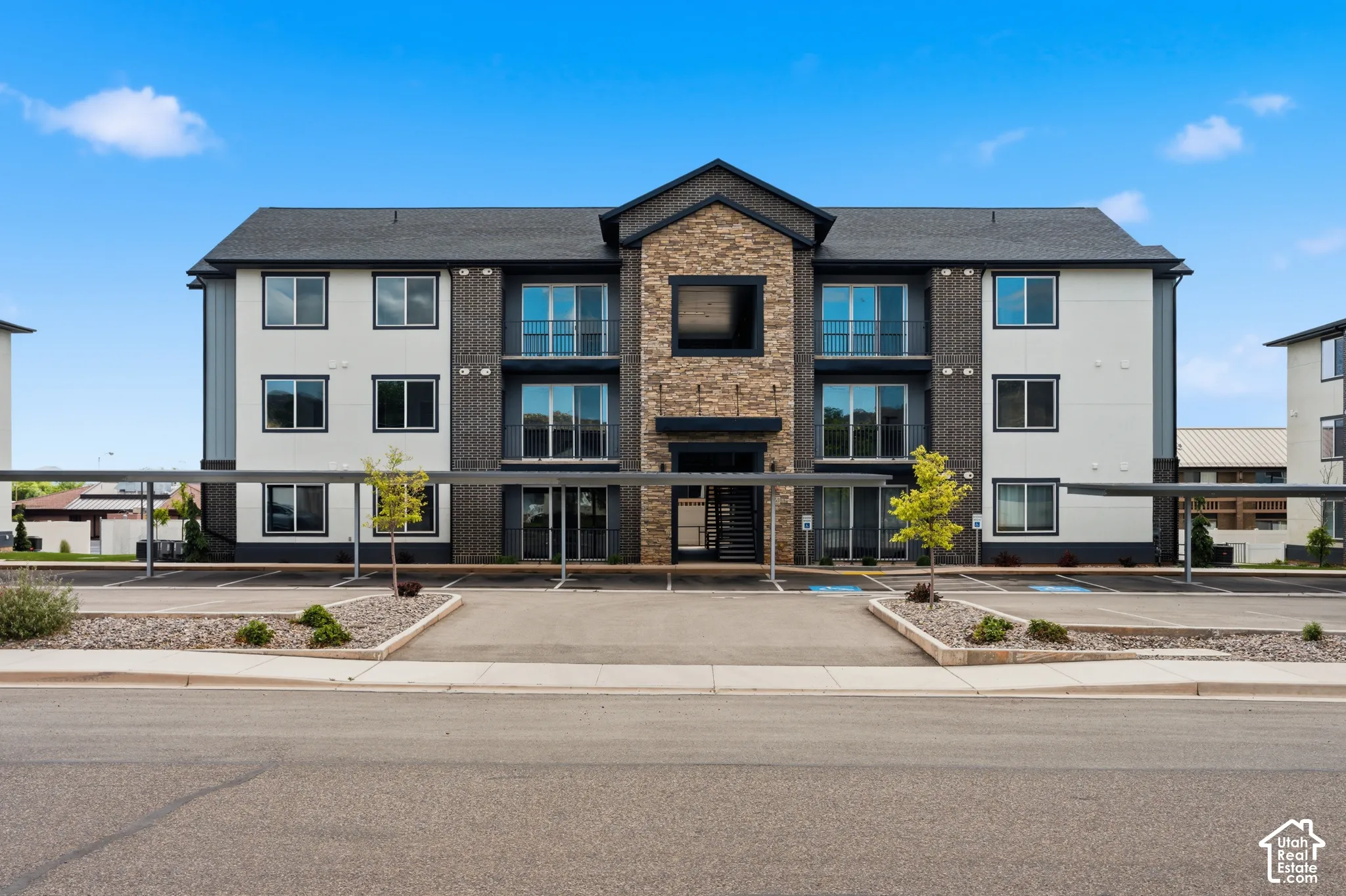 Modern multi-story building featuring a facade with stone accents, horizontal siding, and dark trim