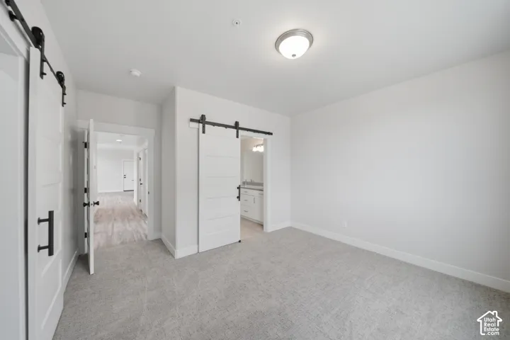 Spacious room featuring light gray carpeting and white walls