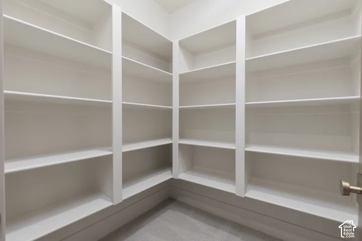 Built-in white shelving with multiple storage levels and carpeted flooring