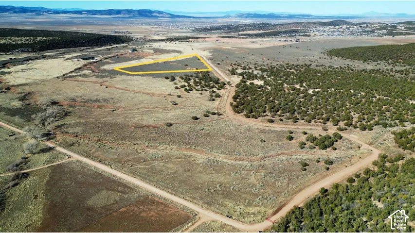 Expansive vacant land parcel featuring native high-desert vegetation, prominent mountain topography, and direct access to an unpaved roadway