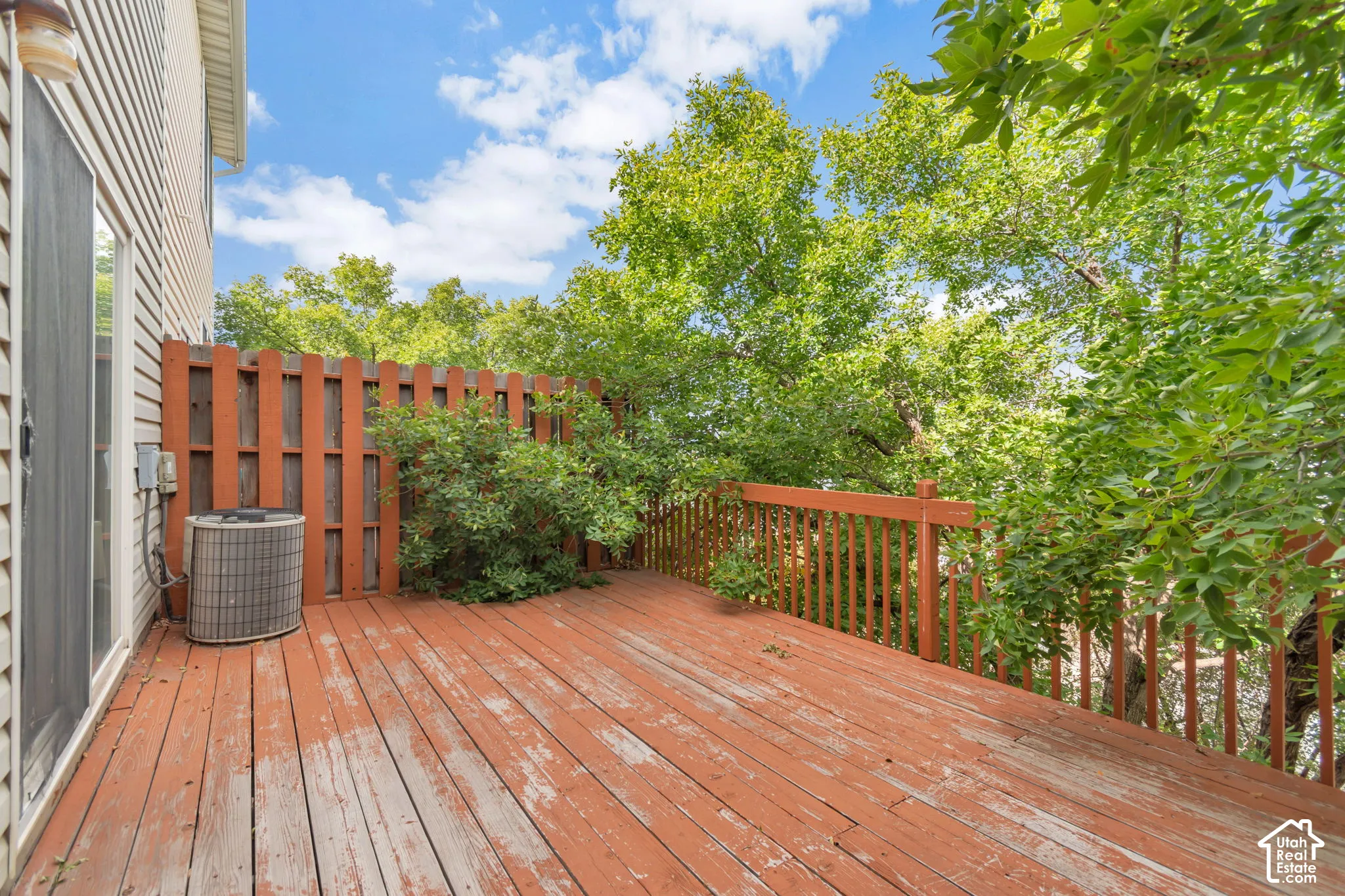 Elevated wooden deck surrounded by mature trees